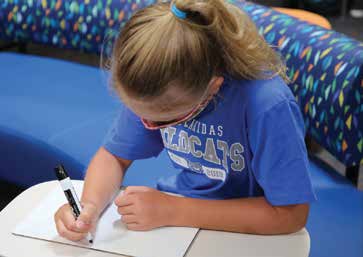   Student writing at a table